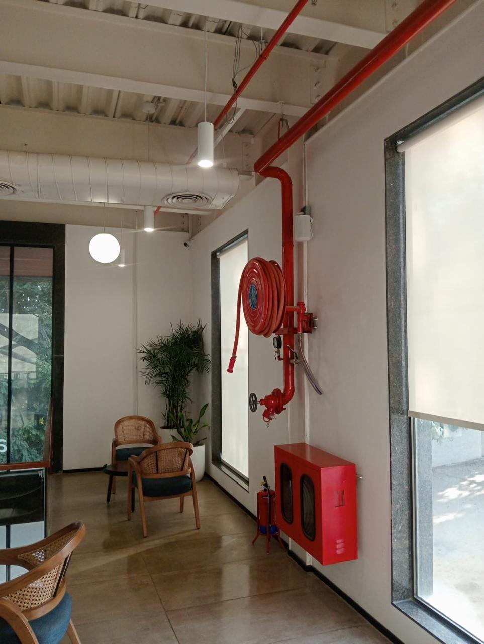 Wall-mounted fire hose reel and hydrant cabinet installed in a corporate lobby by Maroon Peak